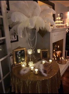 a table topped with candles and pictures next to a fire place covered in white feathers