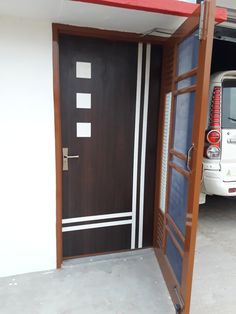 a white van is parked in front of a brown door with red and white trim