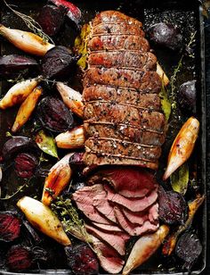 roast beef and beets on a baking sheet with potatoes, carrots and other vegetables