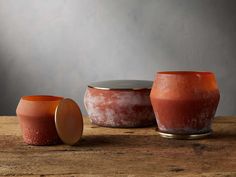 two red pots sitting on top of a wooden table