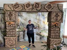 a man standing in front of a wooden arch with carved carvings on the walls and floor