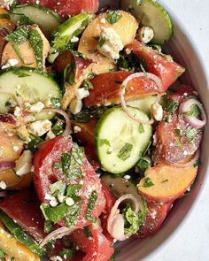 a salad with cucumbers, tomatoes, onions and feta cheese