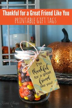 a glass jar filled with candy sitting on top of a table next to a pumpkin