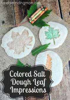 colored salt dough leaf impressions are displayed on a wooden table with crayons and pencils