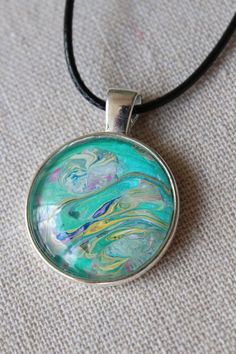 Unique, Colorful, Fun, Bohemian Fluid Art Necklaces. Every necklace is a unique work of art. Made using acrylic fluid art techniques and crafted by selecting the most attractive of color blends and compositions. These necklaces are playful, colorful, and are great additions to any ladies' wardrobe.  They make perfect gifts for any special women in your life whether that be your mother, mother-in-law, your daughters, coworkers, close friends, and they even make a great gift for yourself! Availabl Artistic Round Pendant Necklace, Artistic Necklace With Round Pendant, Artsy Multicolor Round Pendant Necklace, Artsy Multicolor Round Pendant Jewelry, Unique Multicolor Jewelry For Artistic Expression, Artsy Green Pendant Necklace, Multicolor Artistic Pendant Necklace, Artsy Multicolor Necklaces With Artistic Design, Artsy Green Necklaces For Jewelry Making