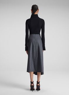 The Clara Skirt is crafted from a pinstripe wool cashmere in a grey melange hue. This asymmetrical midi skirt features a mid-rise relaxed waist with a wrap silhouette and ruched detailing at the hip. Shop Bottoms. Styling Tip: Tuck a slim knit into the skirt and polish off with square-toe boots. Asymmetrical Midi Skirt, Square Toe Boots, Toe Boots, Gray Skirt, Landscaping, Mid Rise, Midi Skirt, Cashmere, Wool