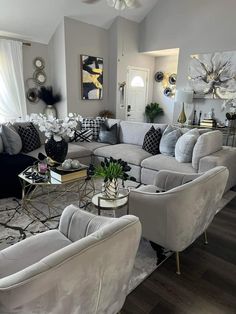 a living room filled with lots of furniture next to a white couch and coffee table