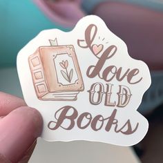 someone holding up a sticker that says i love old books