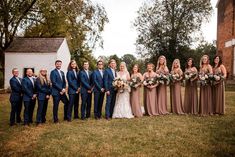 a group of people standing next to each other in front of a building and trees