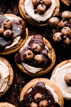 chocolate chip cookies with white frosting and sprinkles are arranged on a cooling rack