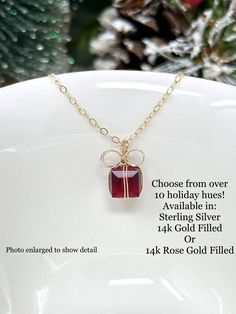 "These handcrafted, adorable present necklaces are such a pretty touch for the holidays! Glimmering Austrian crystals are wrapped up in \"bows\" and sparkle so sweetly. Gracefully suspended from a dainty chain and finished with a polished lobster claw clasp. These will be a holiday favorite that you can cherish for years to come! Choose from 14k yellow gold filled, 14k rose gold filled, or sterling silver and a variety shades of glittering crystal. Pair with The Present earrings for a perfect lo Gift Wrapped Jewelry For Valentine's Day, Handmade Jewelry For Party Gifts, Handmade Jewelry For Parties And Gifts, Handmade Jewelry For Party And Gift-giving Occasions, Red Jewelry Christmas Gift, Red Jewelry For Christmas Gift, Red Christmas Jewelry Gift, Gold Jewelry Gift Wrapped For Gift Giving, Gold Jewelry For Party With Gift Box