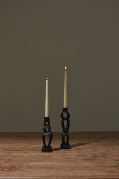 two candles sitting on top of a wooden table