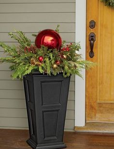 a black planter filled with christmas decorations