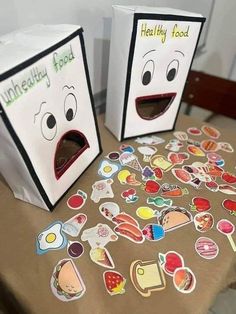 two boxes with stickers on them sitting on a table next to each other, one has an open mouth and the other has eyes