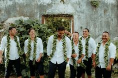 a group of men standing next to each other wearing leis