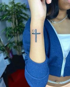 a woman with a cross tattoo on her arm