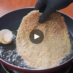 a person in black gloves is frying some food on a pan with an egg