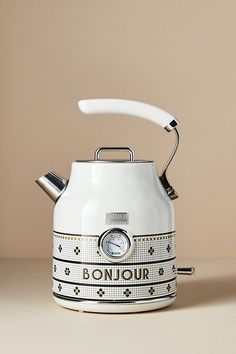 a white and black tea kettle sitting on top of a table