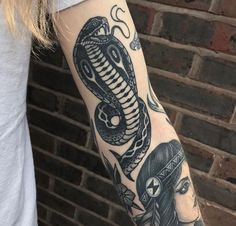 a woman with a snake tattoo on her arm