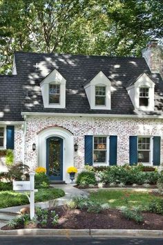 a brick house with blue shutters and white trim