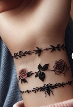 a woman's wrist tattoo with roses and leaves on the side of her arm