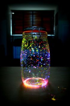 a jar filled with colorful confetti on top of a table