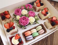 an assortment of desserts and pastries on a tray with flowers in the center