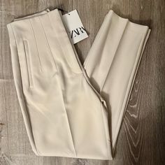 Pants With A High Waist And Pronounced Seams At Front And Back. Front Welt Pockets. Front Zip, Metal Hook, And Interior Button Closure. Measurements Size - Small Waist - 13” Rise - 12” Length - 26” Color - Oyster White Size - Small Condition - Nwt Cream Stretch Straight Leg Pants, Chic Cream Tapered Leg Bottoms, Chic Cream Ankle-length Bottoms, Chic Cream Tapered Leg Pants, Cream Tapered Leg Bottoms For Spring, Cream Stretch Pants For Spring, Stretch Cream Pants, Cream High-waisted Pants For Spring, Spring Cream High-waisted Pants