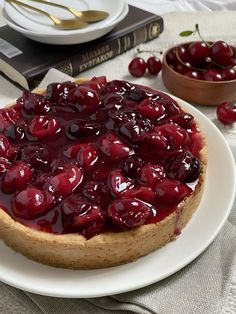 a cherry cheesecake on a white plate with cherries