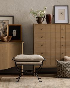 a living room scene with focus on the footstool and dresser in the background