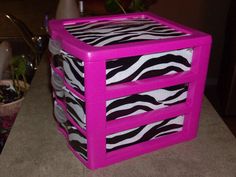 three zebra print drawers sitting on top of a counter next to a potted plant