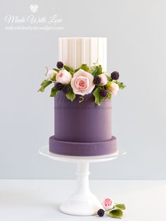 a purple and white cake with flowers on top