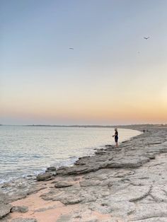 a person standing on the edge of a rocky beach