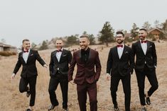 a group of men in tuxedos walking across a field