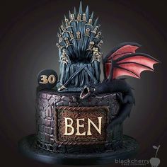 a birthday cake with a game of throne on top and a dragon sitting on top