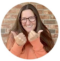 a woman wearing glasses giving the peace sign