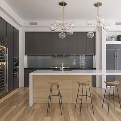 a modern kitchen with wooden floors and gray cabinets is pictured in this image, there are three bar stools at the center of the island