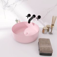 a pink sink with black faucet and soap dispenser next to it