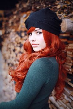 a woman with red hair wearing a black hat