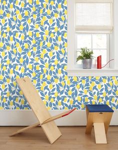 a blue and yellow floral wallpaper in a room with a wooden chair next to it