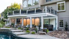 a house with a pool in front of it and landscaping around the back yard area