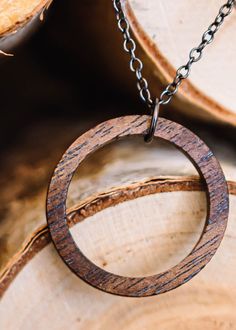 Walnut wood circle pendant is made from walnut wood that has been stained a bit darker than the natural wood. It's sanded smooth with 3 different grits of sandpaper. Chain and findings are gunmetal plated and come in 18in or 24in chain. Clasp is a spring ring. (model in pic is wearing the 18in chain). Circular pendant measures 1.25 in (33mm) Thickness of the pendant is 1/8in (3mm) approximately Please remove before showering/swimming. The polyurethane finish imparts a bit of water resistance, bu Earthy Wooden Jewelry Gift, Earthy Wood Jewelry Gift, Earthy Wood Jewelry As Gift, Rustic Natural Wood Jewelry, Rustic Natural Wood Necklace, Earthy Natural Wood Jewelry For Gifts, Brown Round Nature-inspired Necklaces, Nature-inspired Brown Round Necklaces, Brown Nature-inspired Round Necklaces