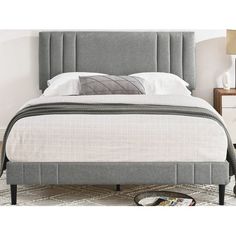 a bed with a gray upholstered headboard and foot board