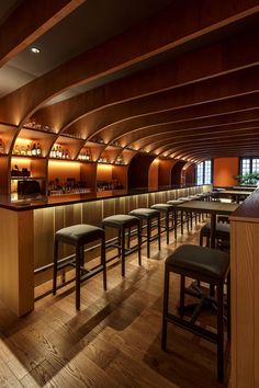 an empty bar with stools and wooden shelves