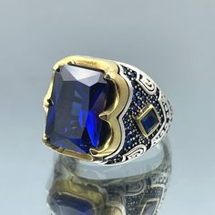 Elevate your style with this exquisite Men's Blue Sapphire Stone Silver Ring, a true masterpiece of Turkish craftsmanship. Handmade with precision and attention to detail, this square stone ring embodies the timeless elegance of Ottoman style jewelry. Crafted from high-quality 925 sterling silver, this ring is not only a statement of your unique taste but also a symbol of enduring quality. The deep blue sapphire stone at its center adds a touch of sophistication and charm, making it a perfect accessory for both casual and formal occasions. Whether you're looking for a meaningful gift for a loved one or a luxurious addition to your own collection, this Turkish handmade ring is a timeless choice that will stand the test of time. Embrace the rich heritage of Ottoman design and adorn your fing Classic Blue Engraved Ring With Polished Finish, Handmade Blue Elegant Signet Ring, Luxury Blue Sapphire Signet Ring, Elegant Blue Signet Ring Stamped 925, Engraved Silver Ring, Mens Silver Jewelry, Silver Ring Designs, Square Stone, Tarnished Silver