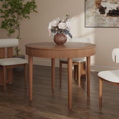 a vase with flowers sitting on top of a wooden table next to two white chairs