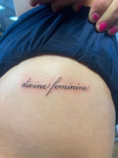 the back of a woman's thigh with an inscription on it that reads divine feminine