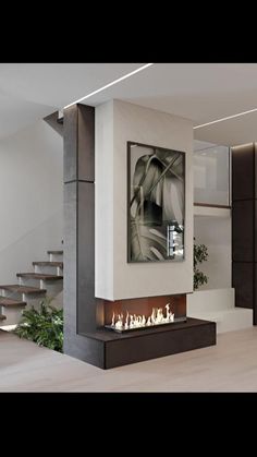 a modern fireplace in the middle of a living room with stairs leading up to it