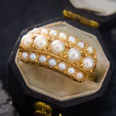 This majestic ring contains two rows of seed pearls encompasing a centered row of larger round pearls. The larger inner pearls and the smaller outer pearls are very well matched. The ring is crafted in buttery 18k yellow gold and is currently a size 6.5. Luxury Baroque Pearl Ring For Anniversary, Luxury Timeless Open Pearl Ring, Vintage Pearl And **** Ring, Luxury Heirloom Pearl Ring, Luxury Elegant Hallmarked Pearl Ring, Luxury Yellow Gold Pearl Ring With Brilliant Cut, Luxury Timeless Yellow Gold Pearl Ring, Chunky Pearls, Pearl Design