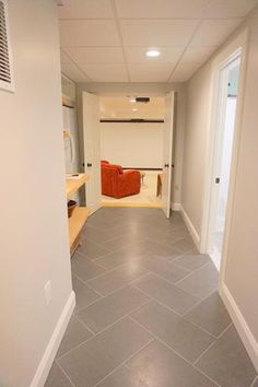 an empty hallway with tile flooring and white walls